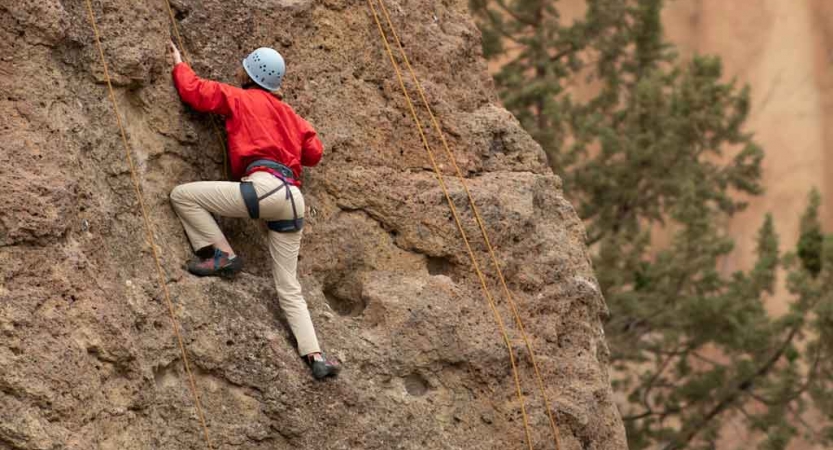 an outward bound student climbs a rock wall on an expedition in the pacific northwest